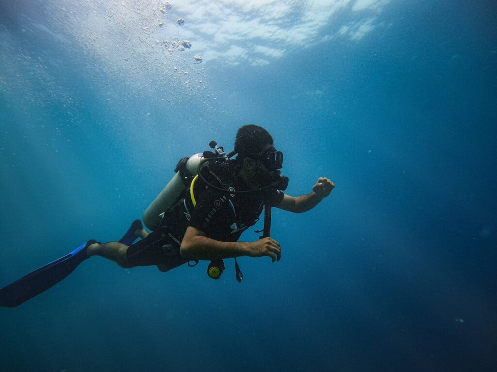 Man in Black Wet Suit Under Water